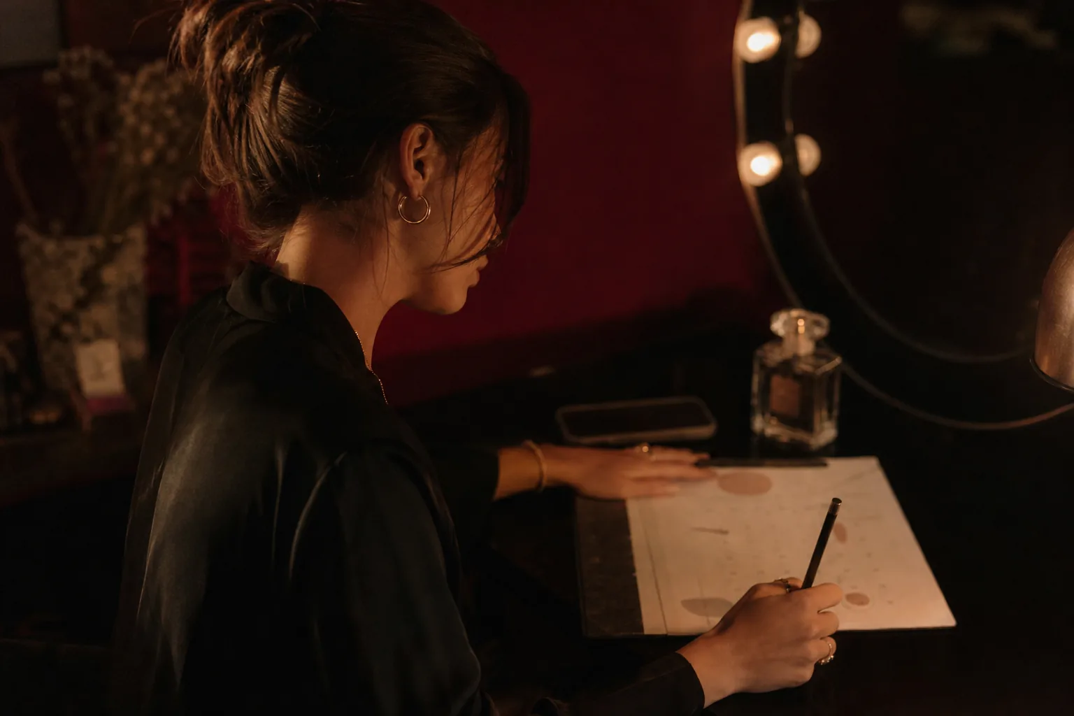 Creator at a vanity table planning her month with a calendar and her phone